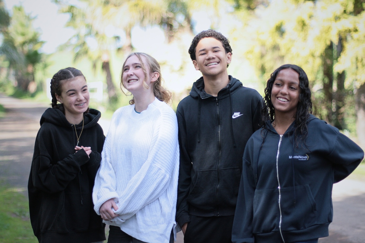 Four MonteNova Academy learners smiling together outdoors