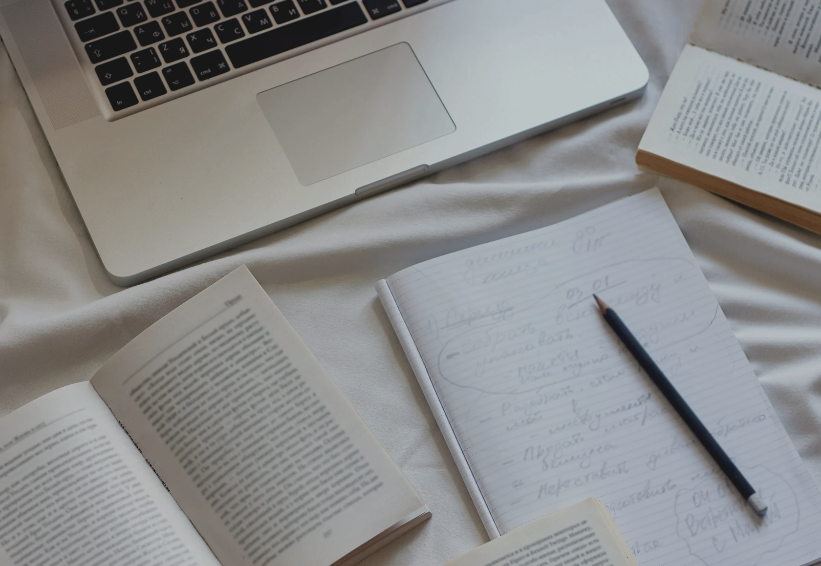 Open book, notebook, and laptop for MonteNova Academy About page