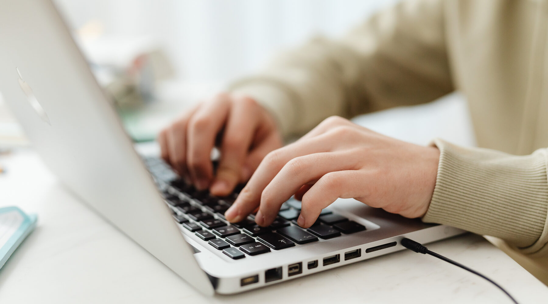 Hands typing on a laptop for enrolment and enquiry support